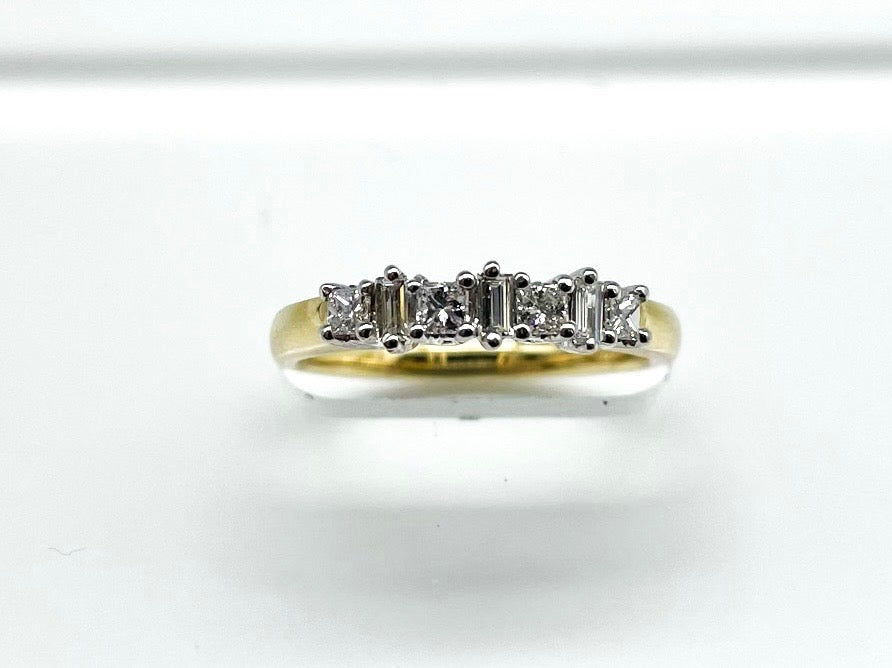 .20 Point Round Brilliant Cut and .12 Point Baguette Cut Diamond Ring